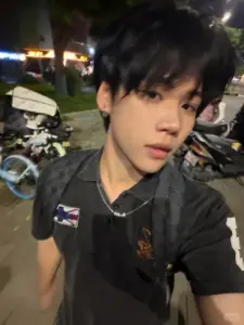 Buổi tối ngoài phố lên màu ấm, áo polo đen và tóc rối tự nhiên